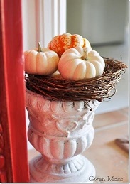 Urn topped with a wreath and stacked with pumpkins